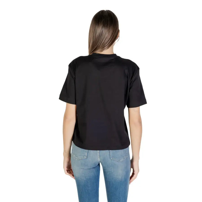 Woman from behind wearing a Calvin Klein Jeans black round neck short sleeve T shirt and blue jeans