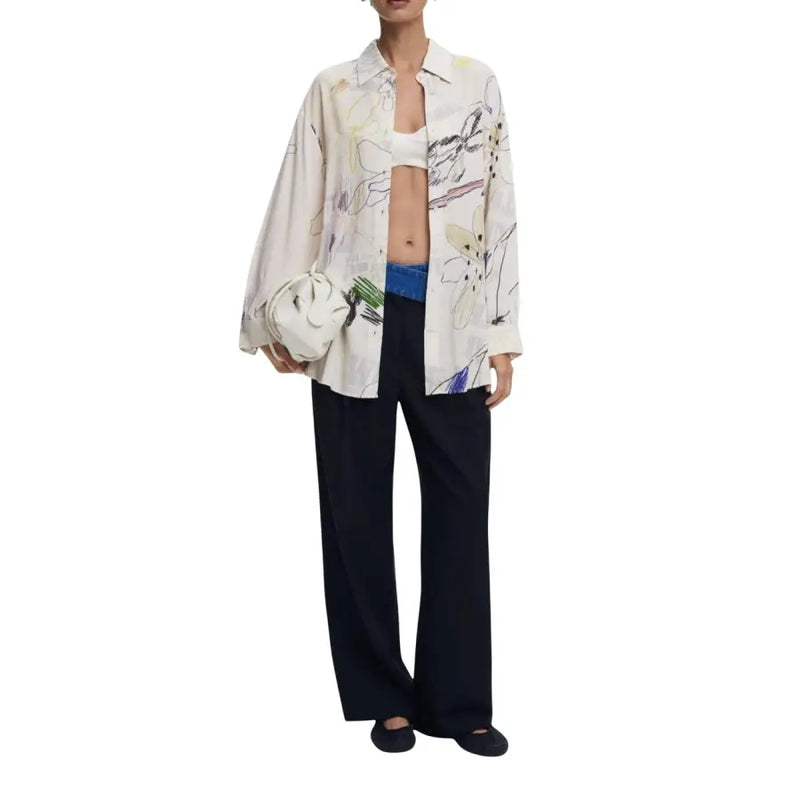 Woman wearing Desigual Classic Long Beige Viscose Shirt with black trousers and white clutch