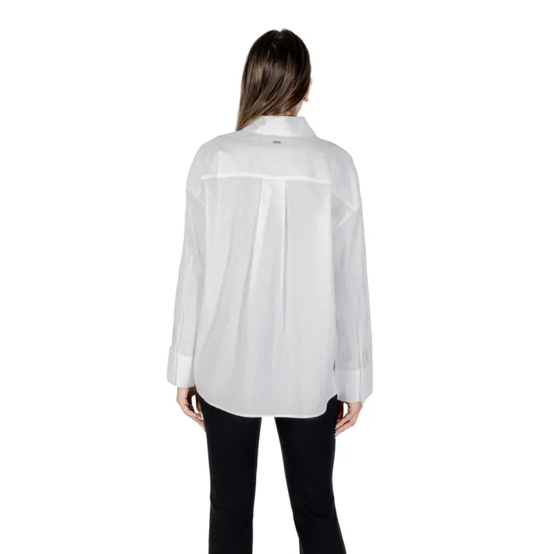 Woman wearing Armani Exchange white cotton long sleeve collared shirt and black pants