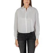 Woman wearing Armani Exchange white cotton long sleeve button shirt and dark jeans