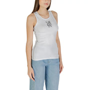 Woman wearing Calvin Klein Jeans white sleeveless round neck tank top with black contrast stitching and light blue wide-leg jeans