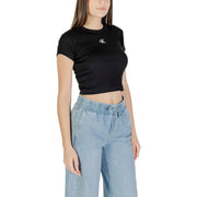 Woman wearing black Calvin Klein crop top and light blue wide-leg jeans