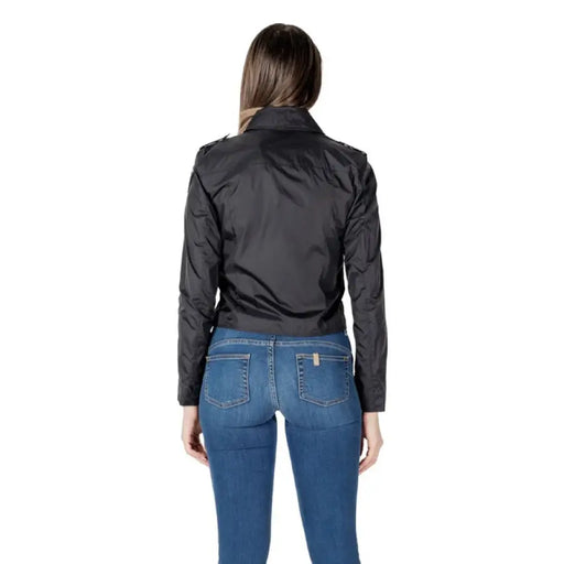Woman wearing black moto jacket and blue jeans, stylish casual outfit image