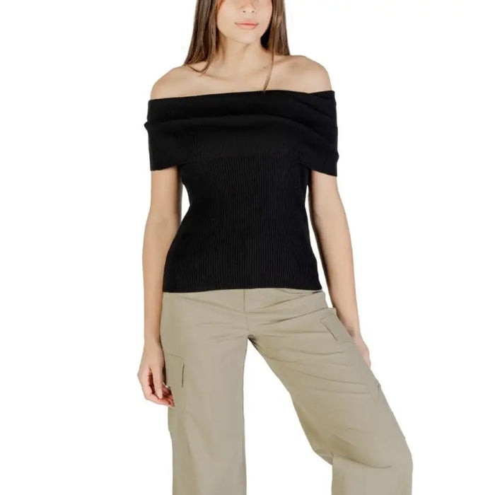 Woman wearing black off-the-shoulder ribbed top with khaki pants for fashion style