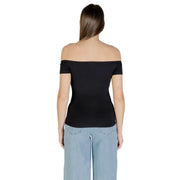Woman wearing Calvin Klein Jeans black print boat neck top with light blue wide-leg pants