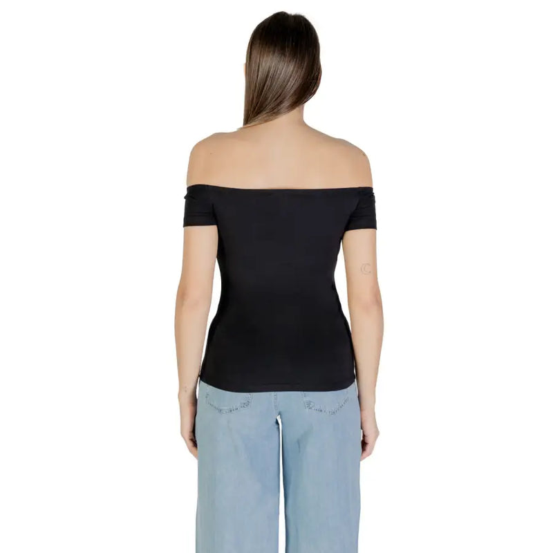 Woman wearing Calvin Klein Jeans black print boat neck top with light blue wide-leg pants