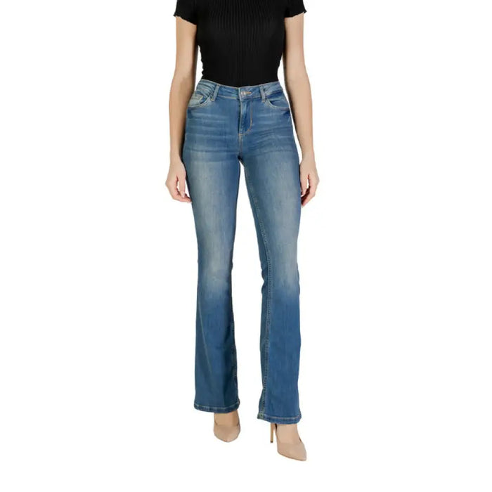 Woman wearing blue denim flare jeans for women product display