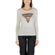 Woman wearing a light gray long-sleeved Guess shirt with metallic triangular logo