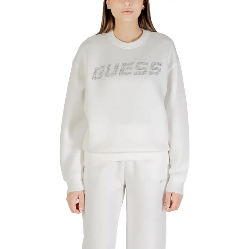 Woman wearing a long-sleeved white sweatshirt with rhinestone GUESS logo on chest