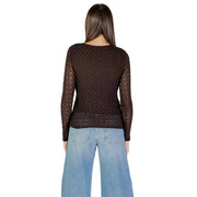 Woman wearing sheer brown long-sleeved round neck T-shirt with light wash wide-leg jeans