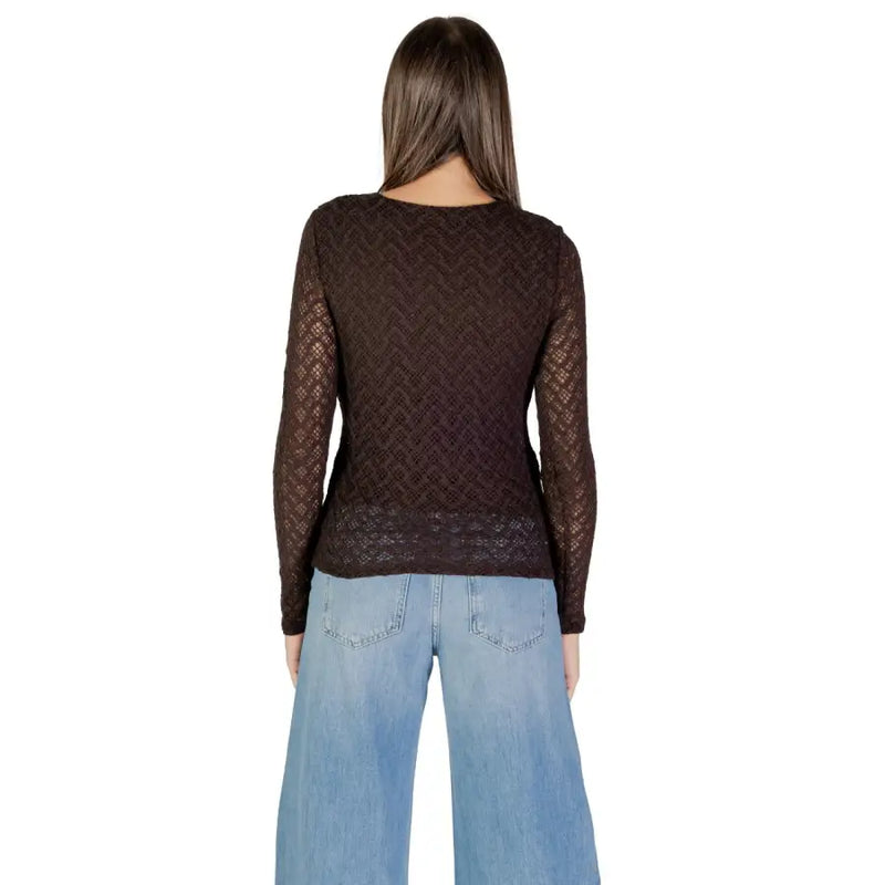 Woman wearing sheer brown long-sleeved round neck T-shirt with light wash wide-leg jeans