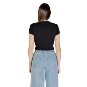 Woman wearing Calvin Klein Jeans black printed short sleeve crop top with light blue wide-leg jeans