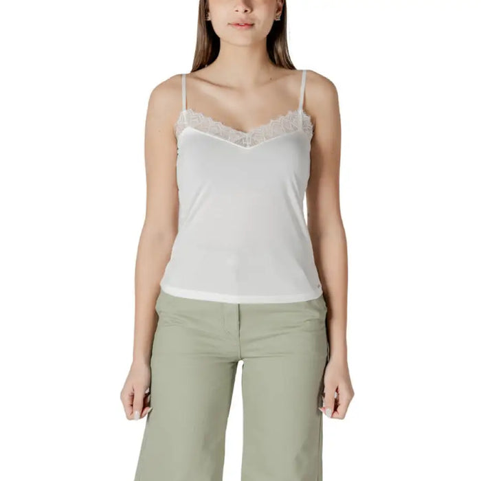 Woman wearing a white lace-trimmed camisole and green pants for Women’s White Lace Trim Camisole and Green Pants