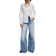Woman wearing Desigual white long sleeve shirt with light wash wide-leg jeans for fall winter