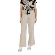 Woman wearing tropical print short-sleeve top beige wide-leg pants and white platform sneakers