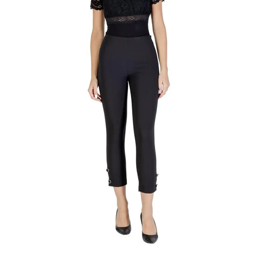 Women’s black high-waisted capri trousers with buckle cuffs, paired with a lace top and heels