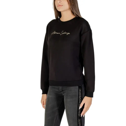 Women wearing Armani Exchange black long-sleeve crew-neck sweatshirt with embroidered chest text and matching side-stripe sweatpants