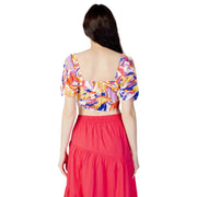 Women wearing a colorful floral crop top and tiered red maxi skirt for spring summer fashion