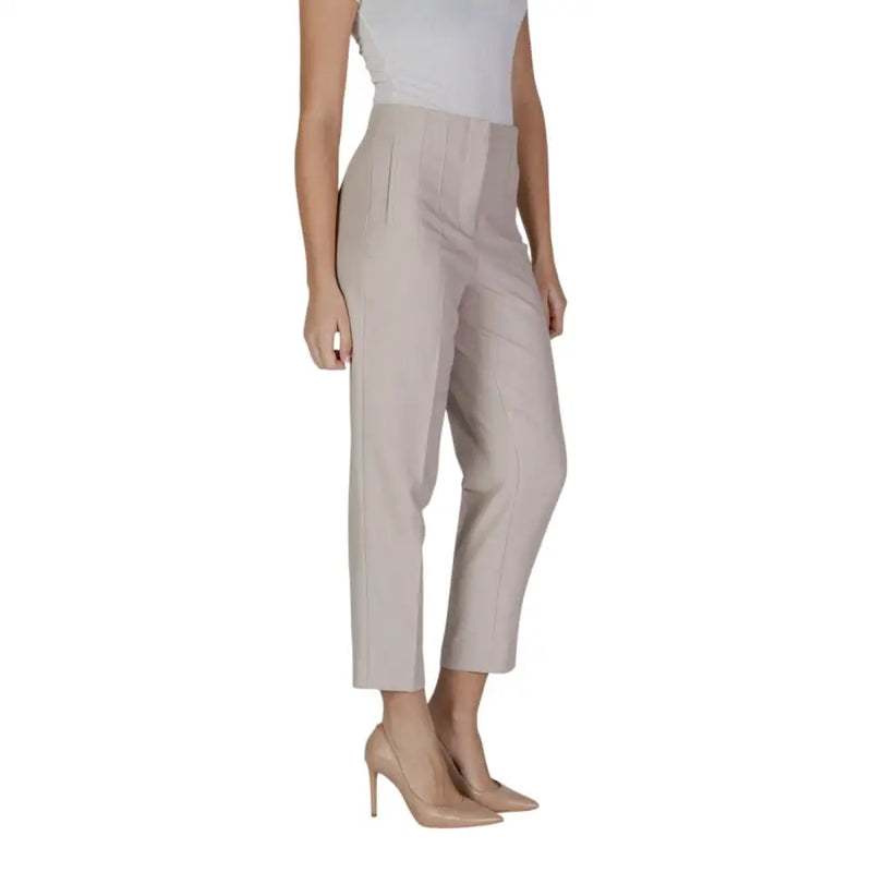 Women’s beige high-waisted cropped trousers with nude high heels, front pockets, and button closure