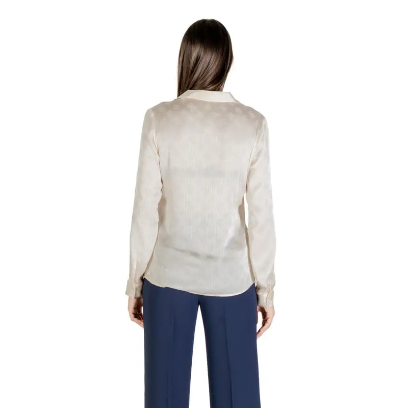 Women’s beige long sleeve button-up shirt with round neck paired with dark blue wide-leg pants