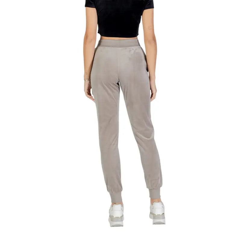 Women’s taupe velvet joggers with black crop top and white sneakers in Guess Active product image