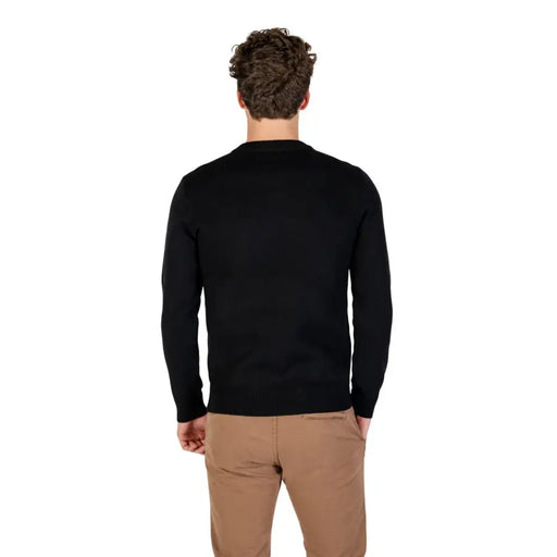 Black v-neck sweater with ribbed cuffs and hem, likely made of cotton or polyester blend.