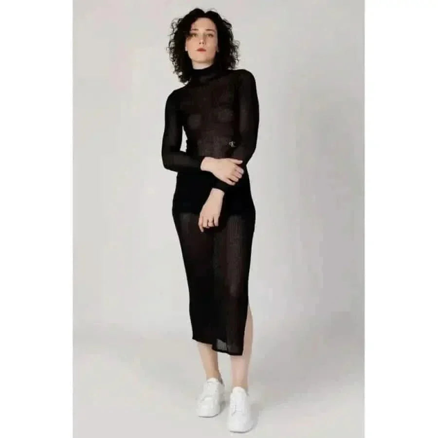 Black sheer turtleneck dress with white sneakers and high slit