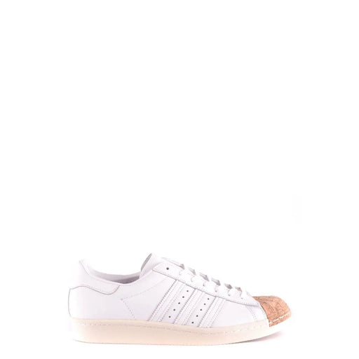 Adidas Baskets en cuir blanc pour homme, style slip sport, bout renforcé en liège et semelle en caoutchouc couleur crème.