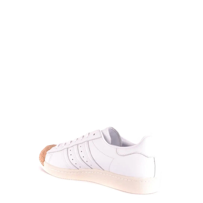 Adidas Baskets en cuir pour homme, blanches, style slip-on, avec bout renforcé en cuir blanc et caoutchouc beige et semelle en gomme.