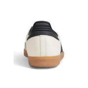 Adidas women leather sneakers featuring a black and cream samba design with white laces and gum rubber sole