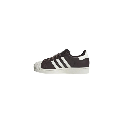Adidas Baskets Superstar en cuir marron pour femme, avec empeigne en daim marron foncé, embout en caoutchouc blanc et trois bandes.