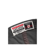 Black baseball cap with red and white logo, american needle archive collection label.