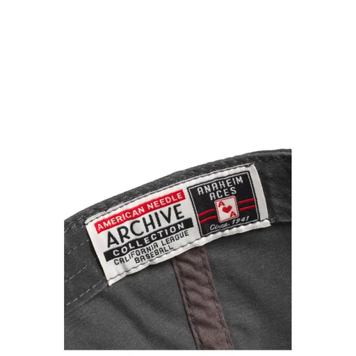 Black baseball cap with red and white logo, american needle archive collection label.