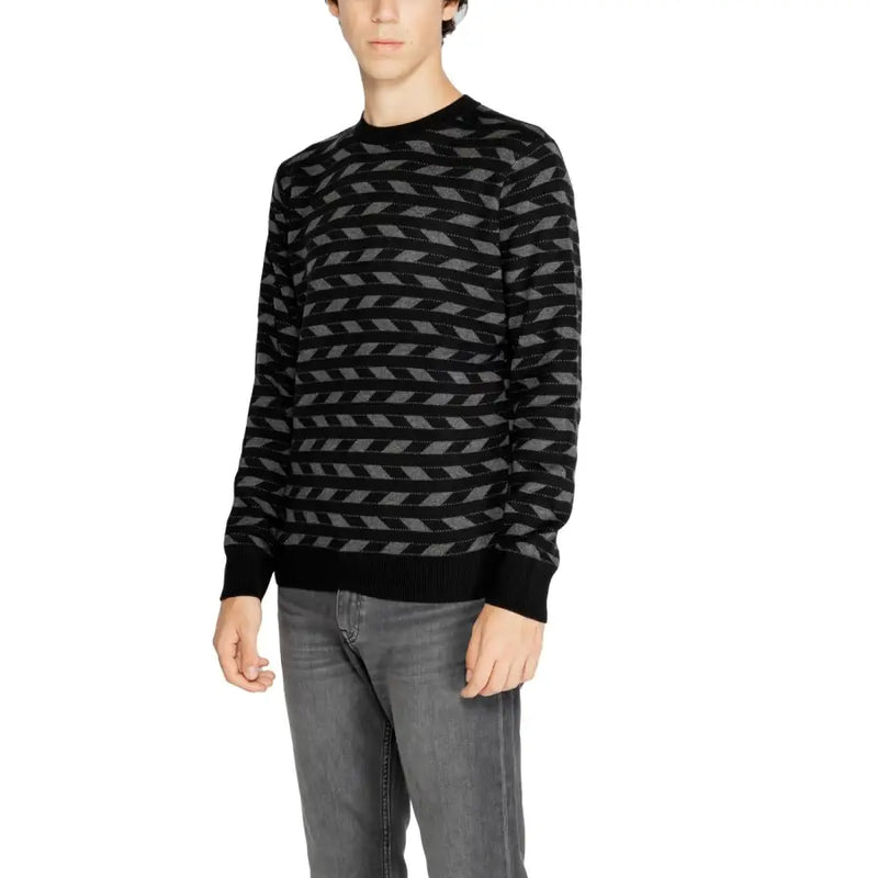 Black and gray geometric patterned sweater with ribbed cuffs and hem, likely made of cotton or wool.