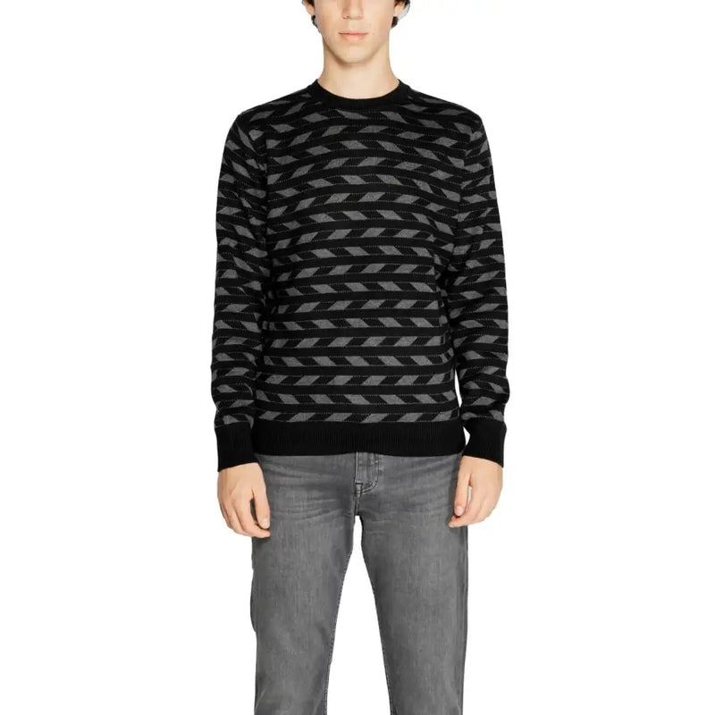 Black and gray geometric patterned sweater with ribbed cuffs and hem.