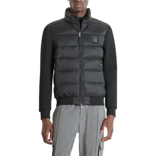 Black and gray down jacket with a high collar, zipper closure, and brand logo on the chest.