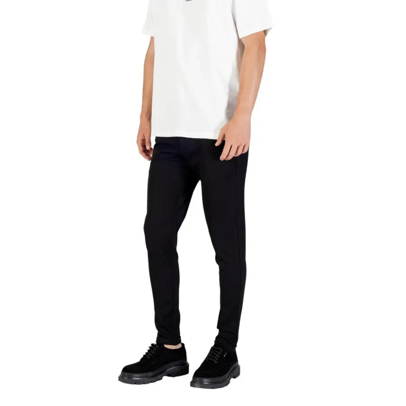 Men’s white short-sleeve crewneck T-shirt paired with black skinny jeans and black lace-up shoes