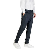Men’s dark blue slim-fit trousers paired with a white long-sleeve shirt and white sneakers