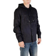 Men’s black hooded utility blazer with front pockets and drawstrings paired with blue jeans