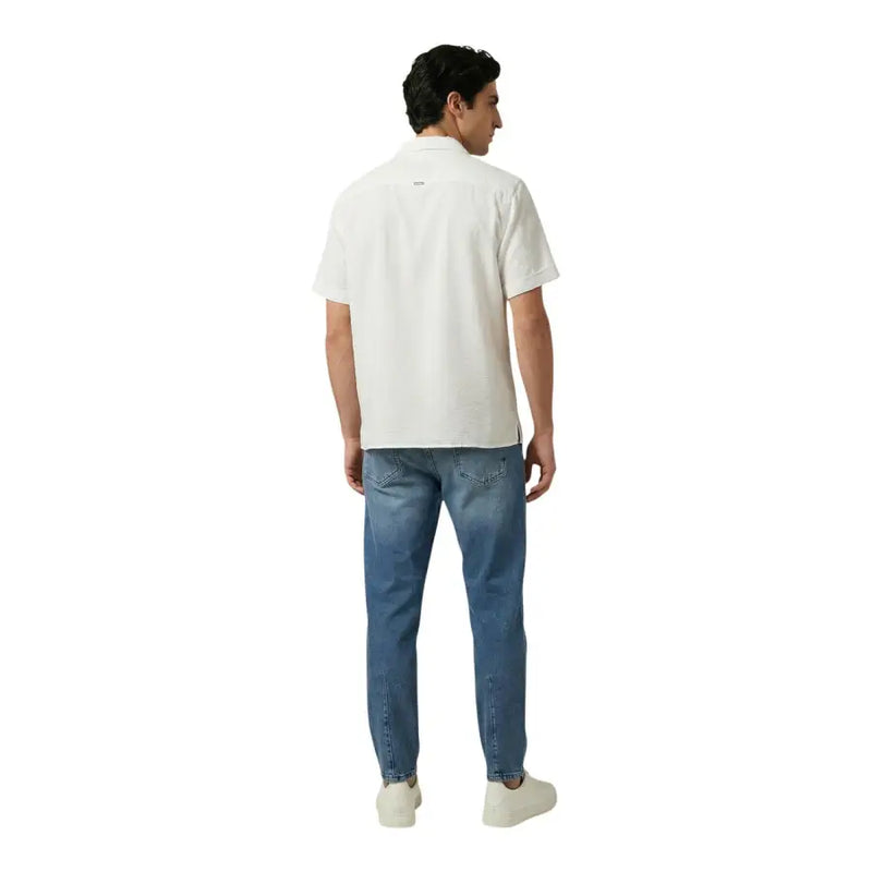Un homme portant le dos d'un Antony Morato polo blanc à manches courtes avec un logo discret et jean bleu clair