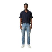 Un jean en denim délavé clair et usé, avec des déchirures aux genoux et aux cuisses, pour homme. Antony Morato