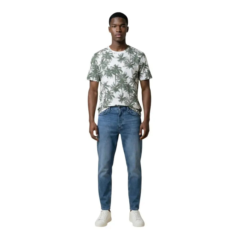 A man wearing an Antony Morato men’s white t-shirt with green palm tree print and blue jeans