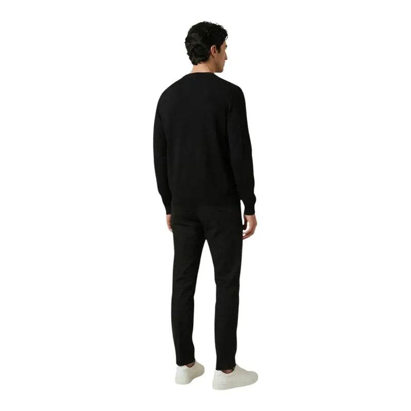 Antony Morato pantalon pour homme associé à un pull noir à col rond, à manches longues et à la silhouette ajustée.