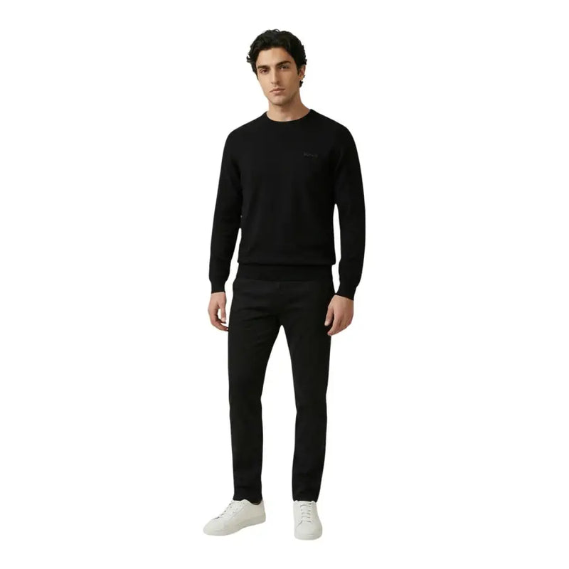 Antony Morato Pantalon pour homme porté avec un pull en maille noire orné d'un logo brodé discret sur la poitrine gauche