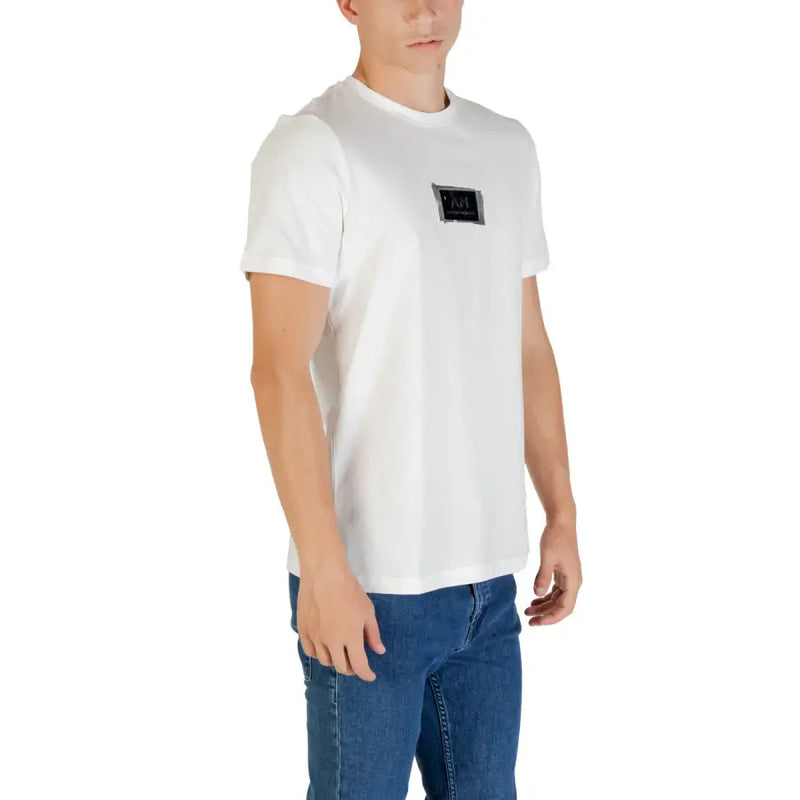 Men’s white short-sleeve cotton T-shirt with black chest patch and blue jeans