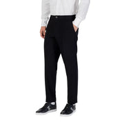Men’s black trousers with white button-up shirt and black sneakers from Armani Exchange