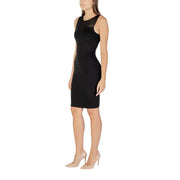 Woman wearing Armani Exchange black sleeveless sheath dress with mesh neckline and nude pumps