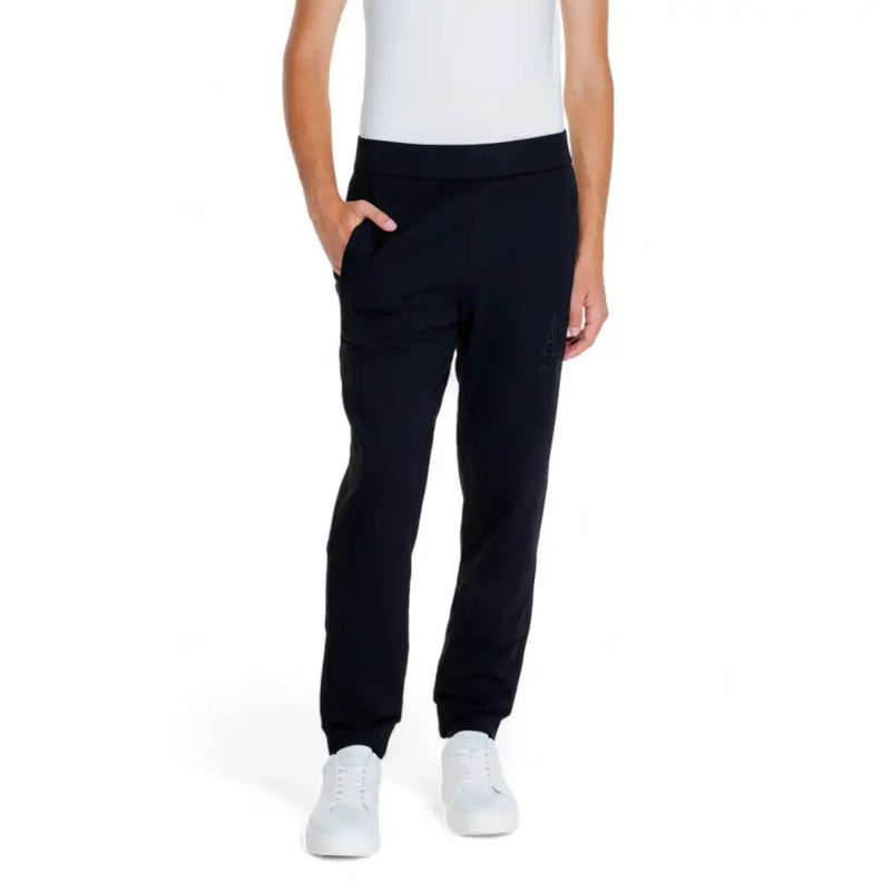 Person wearing black cotton trousers and a white sleeveless top for Armani Exchange Men