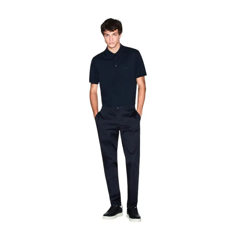Un homme portant un Armani Exchange Polo bleu en coton à manches courtes pour homme, avec un logo brodé discret sur la poitrine.