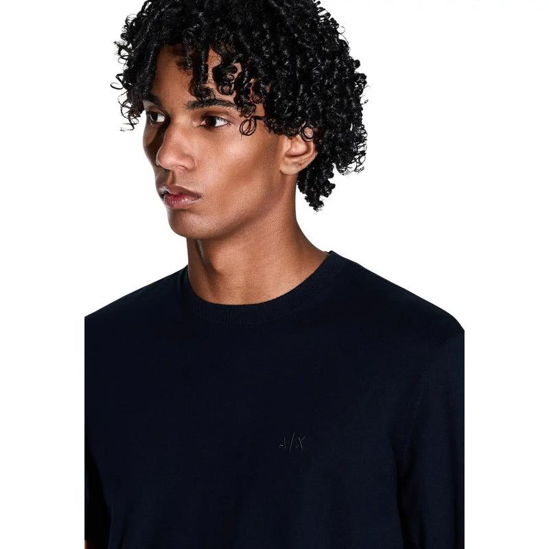 Armani Exchange T-shirt noir en coton pour homme, col rond, avec logo brodé discret sur la poitrine gauche.